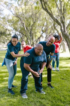 Group of adults enjoying a lively team building activity in a sunny park setting, promoting unity and fun.